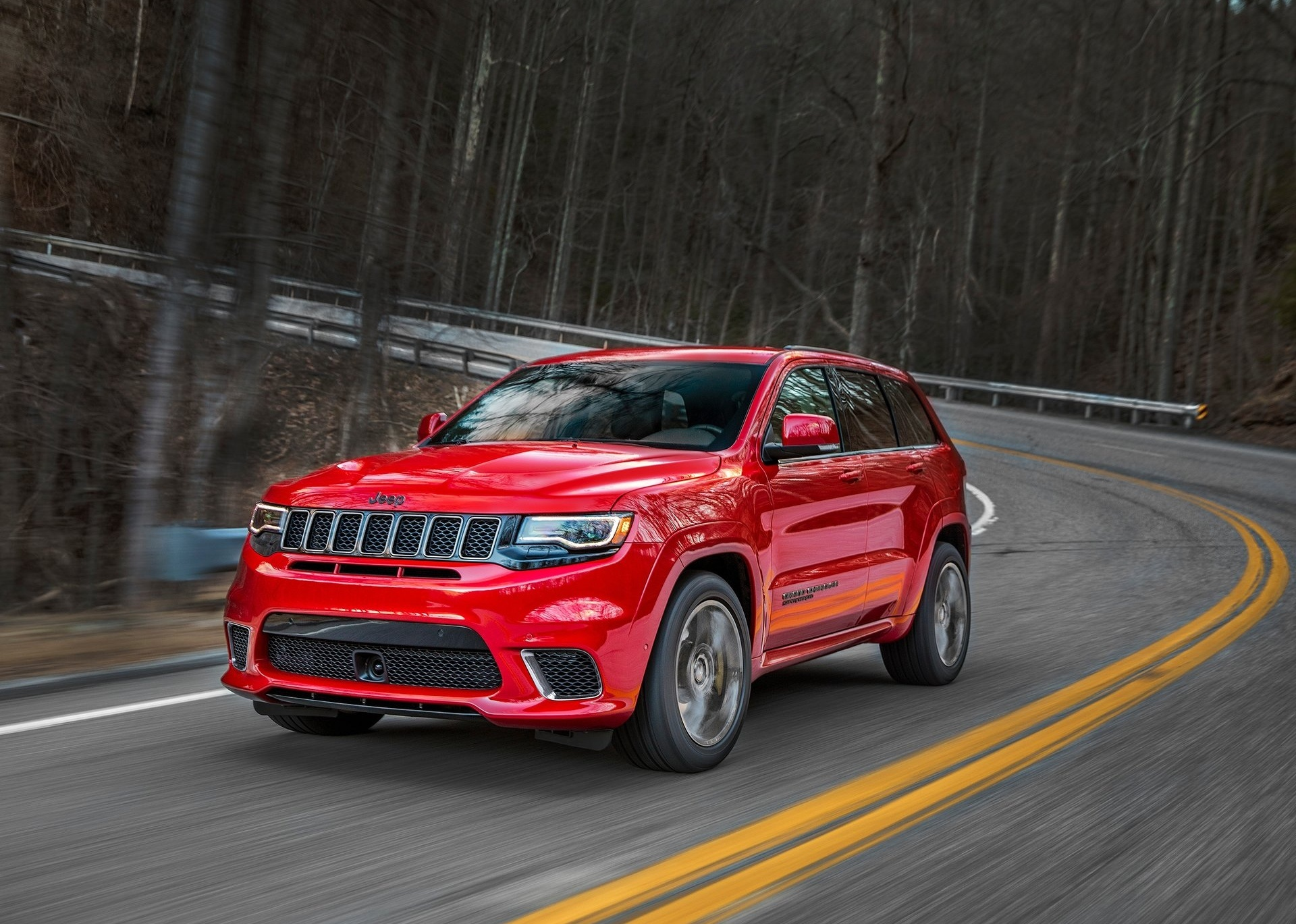 Red SUV driving on a winding road in a real-world vehicle application scene